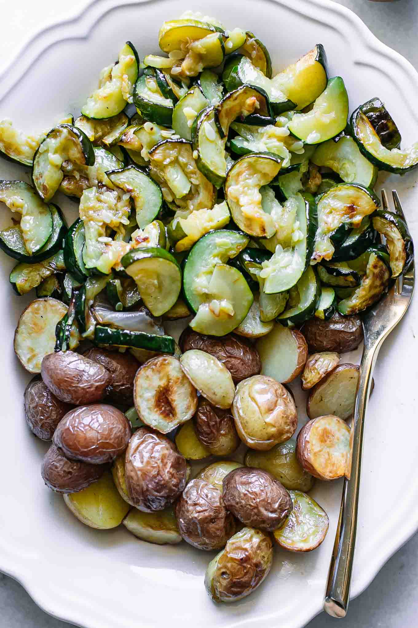 baked potato and zucchini slices on a white serving plate