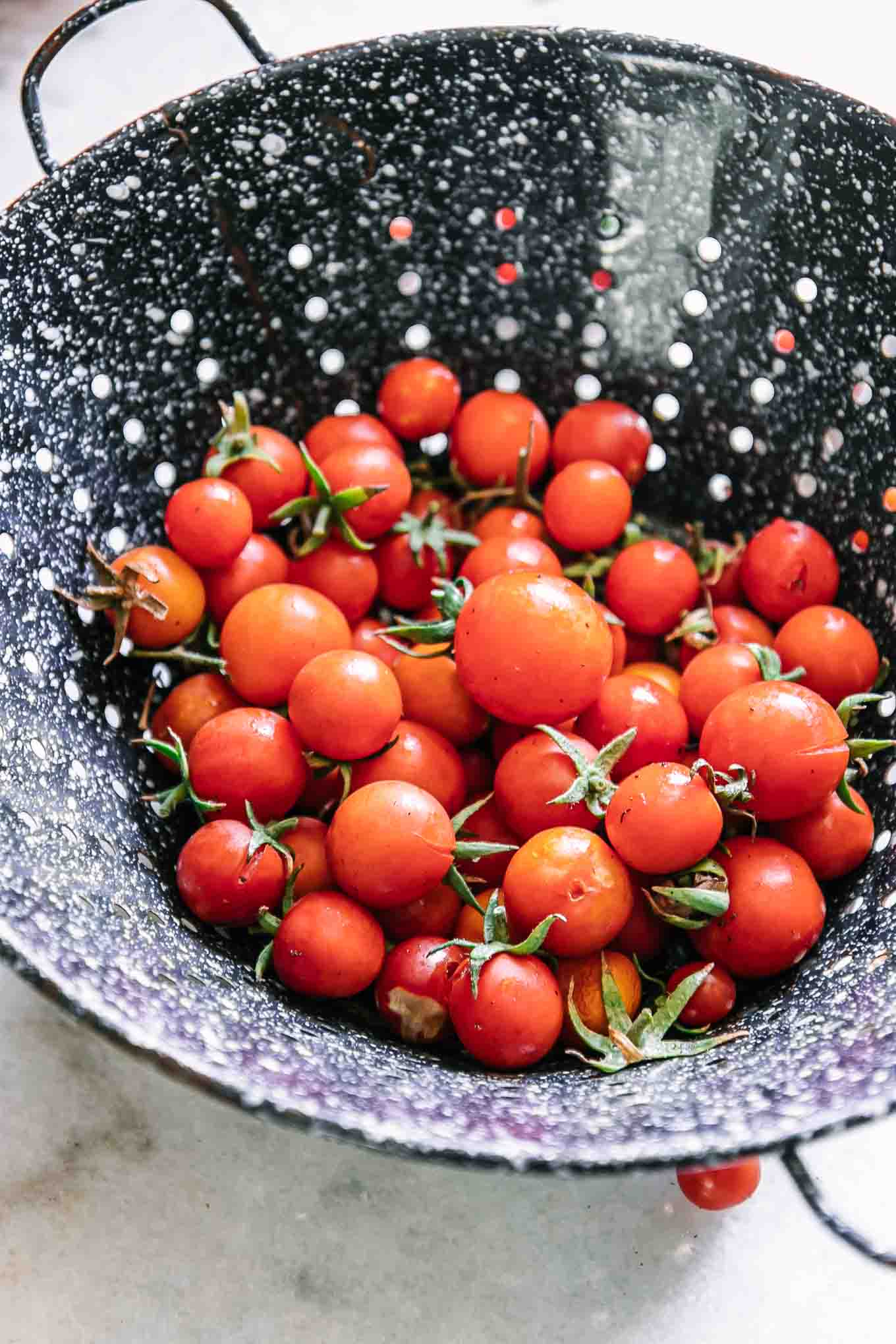 washed cherry tomatoes in a blue colander