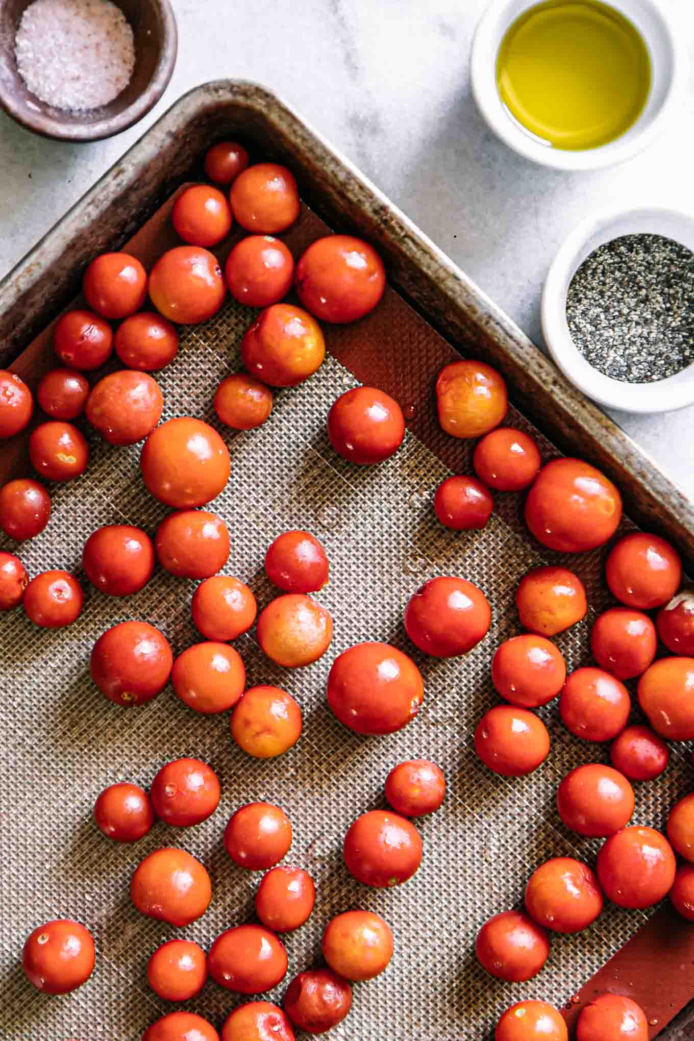 fresh cherry tomatoes on a roasting pan before baking