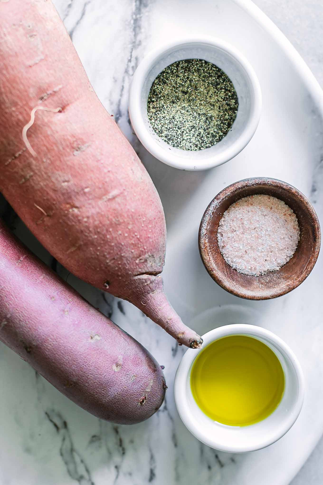 sweet potatoes, oil, salt, and pepper on a white table