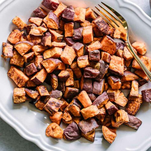 crispy roasted sweet potatoes on a white plate