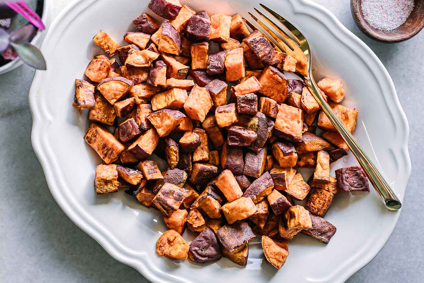 crispy roasted sweet potatoes on a white plate