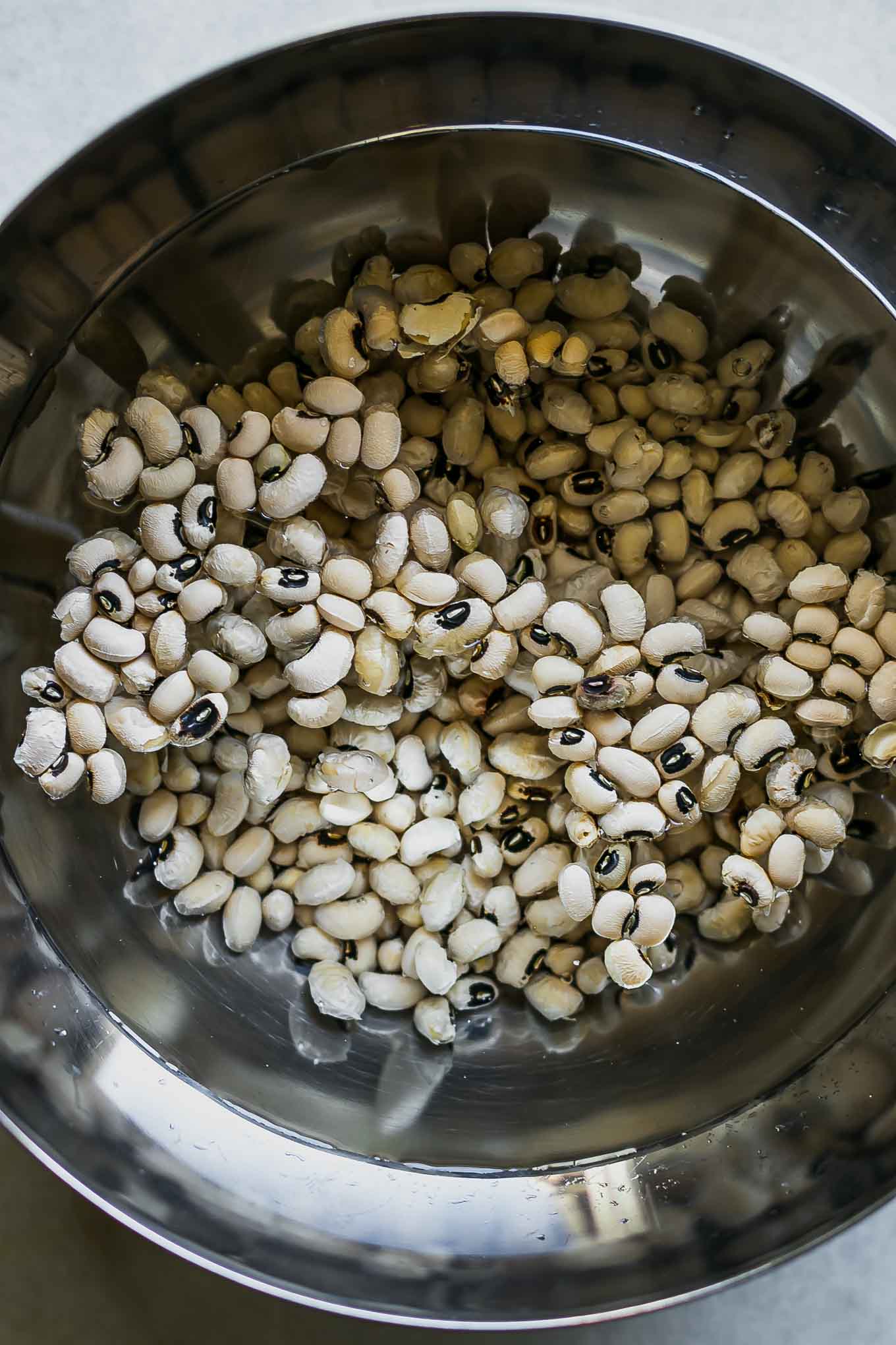 a bowl of black eyed peas soaking in water