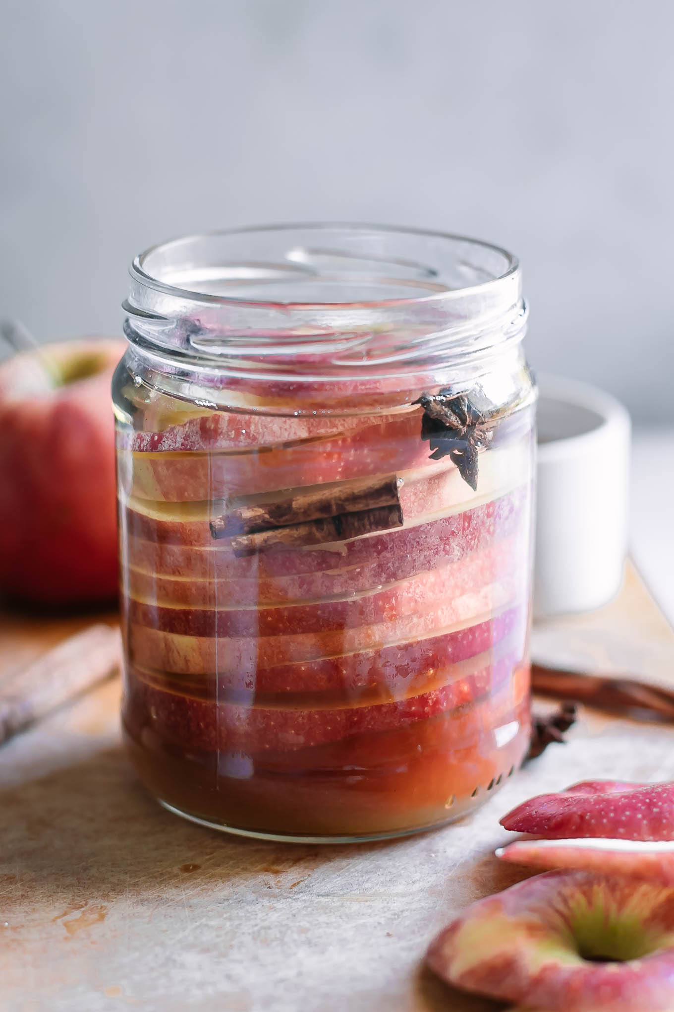 apple slices in a jar with cinnamon and star anise before pickling