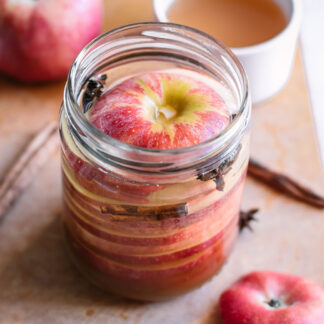 pickled apples in a jar with cinnamon sticks and star anise