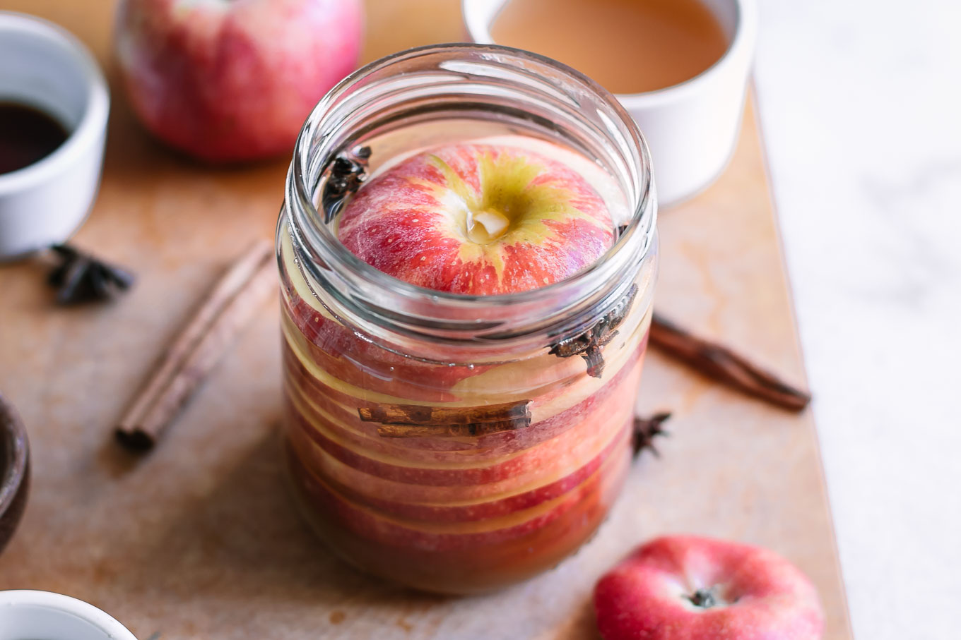pickled apples in a jar with cinnamon sticks and star anise