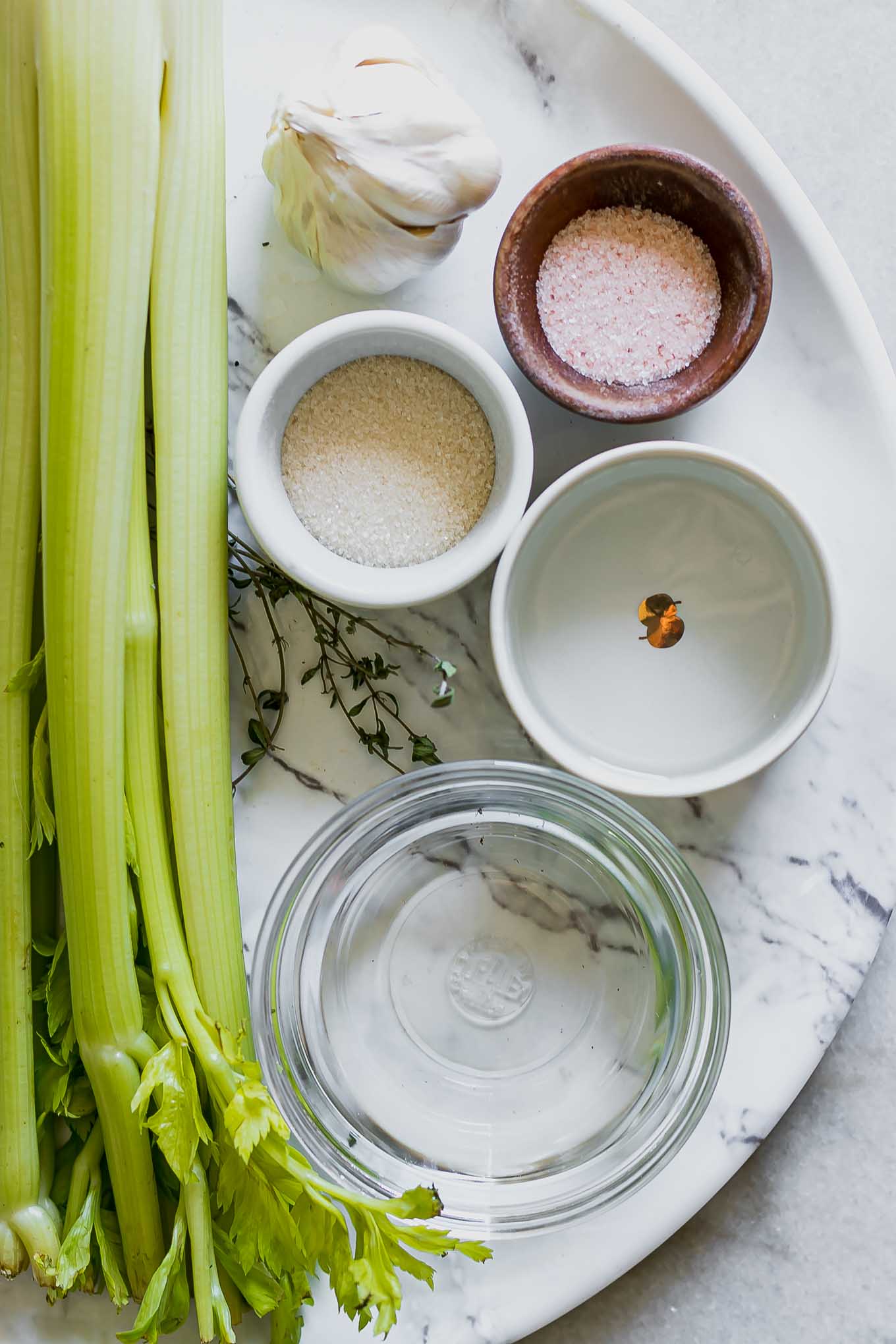 celery, garlic, water, vinegar, sugar, and salt on a table before pickling