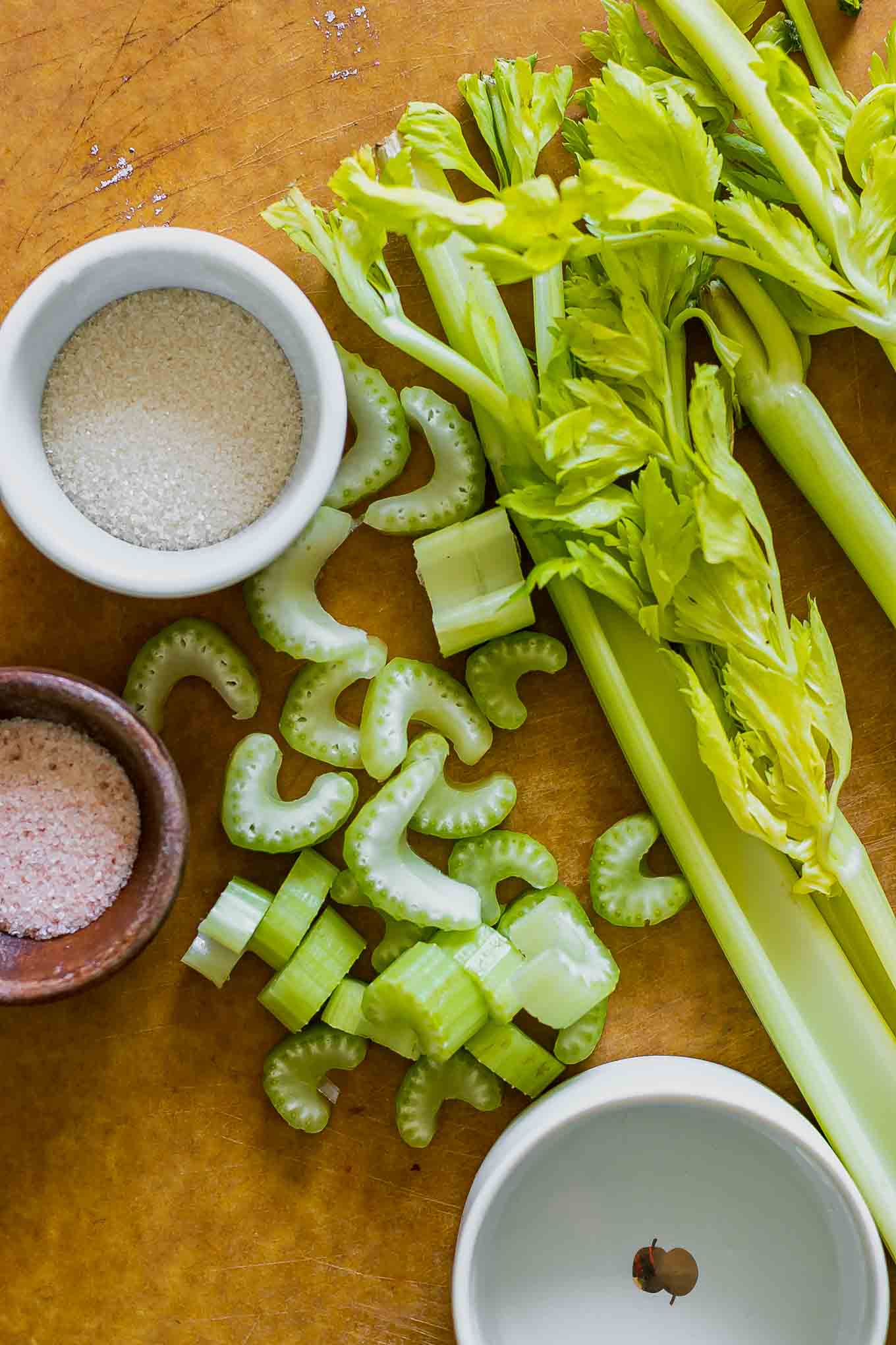 sliced celery on a wood cutting board before pickling