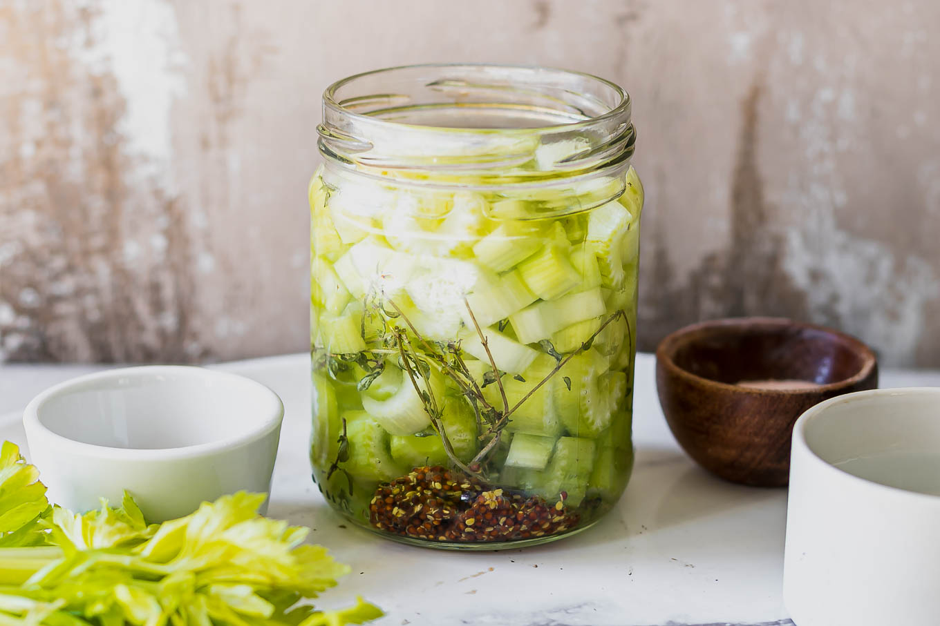 refrigerator pickled celery in a jar on a white table