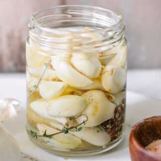 pickled garlic in a jar on a white table