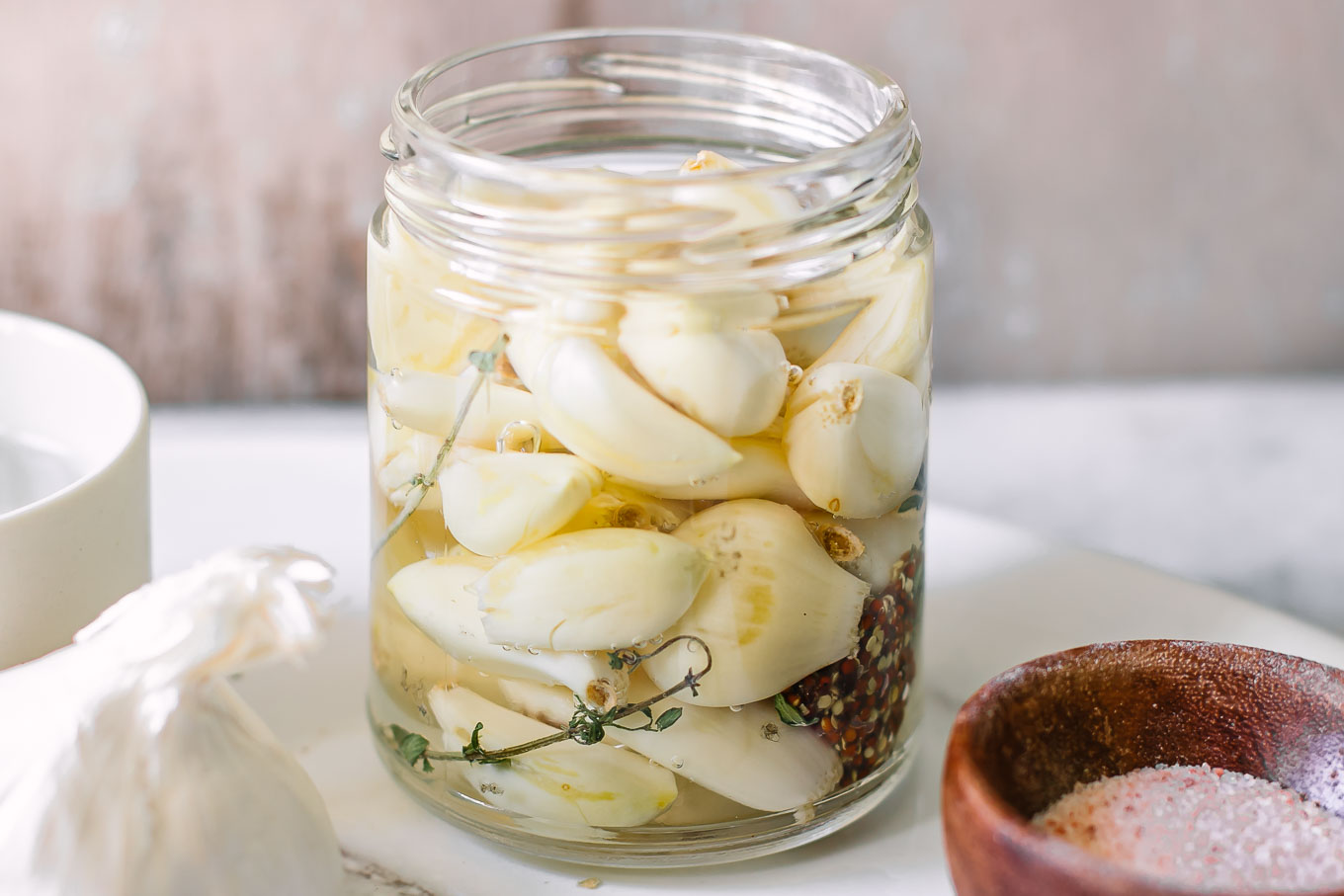 pickled garlic in a jar on a white table