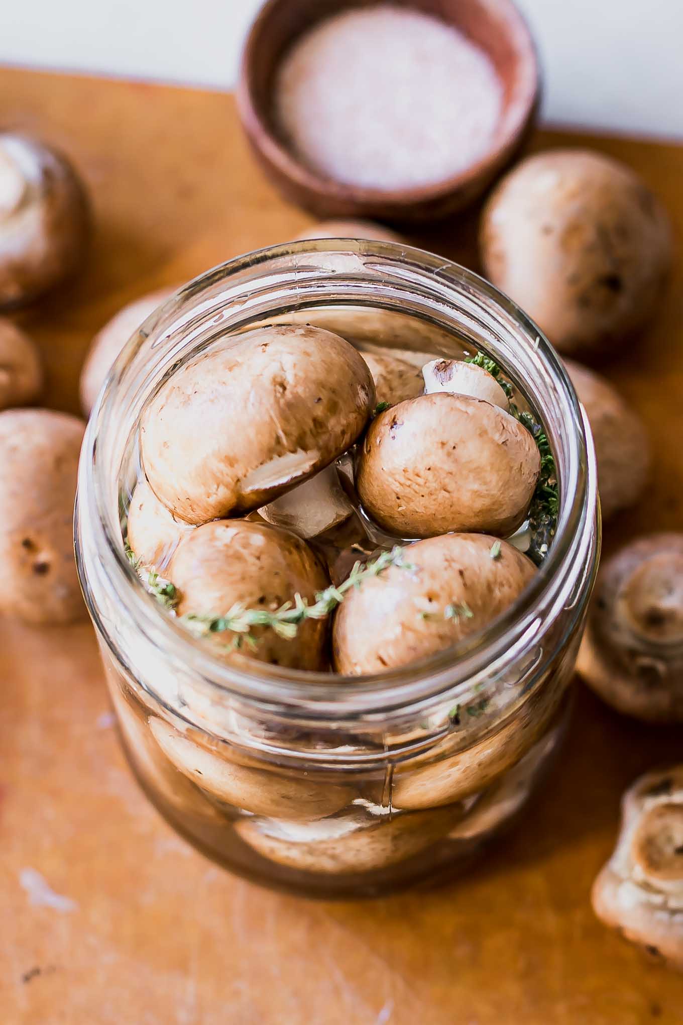 pickled mushrooms in a jar with a vinegar brine