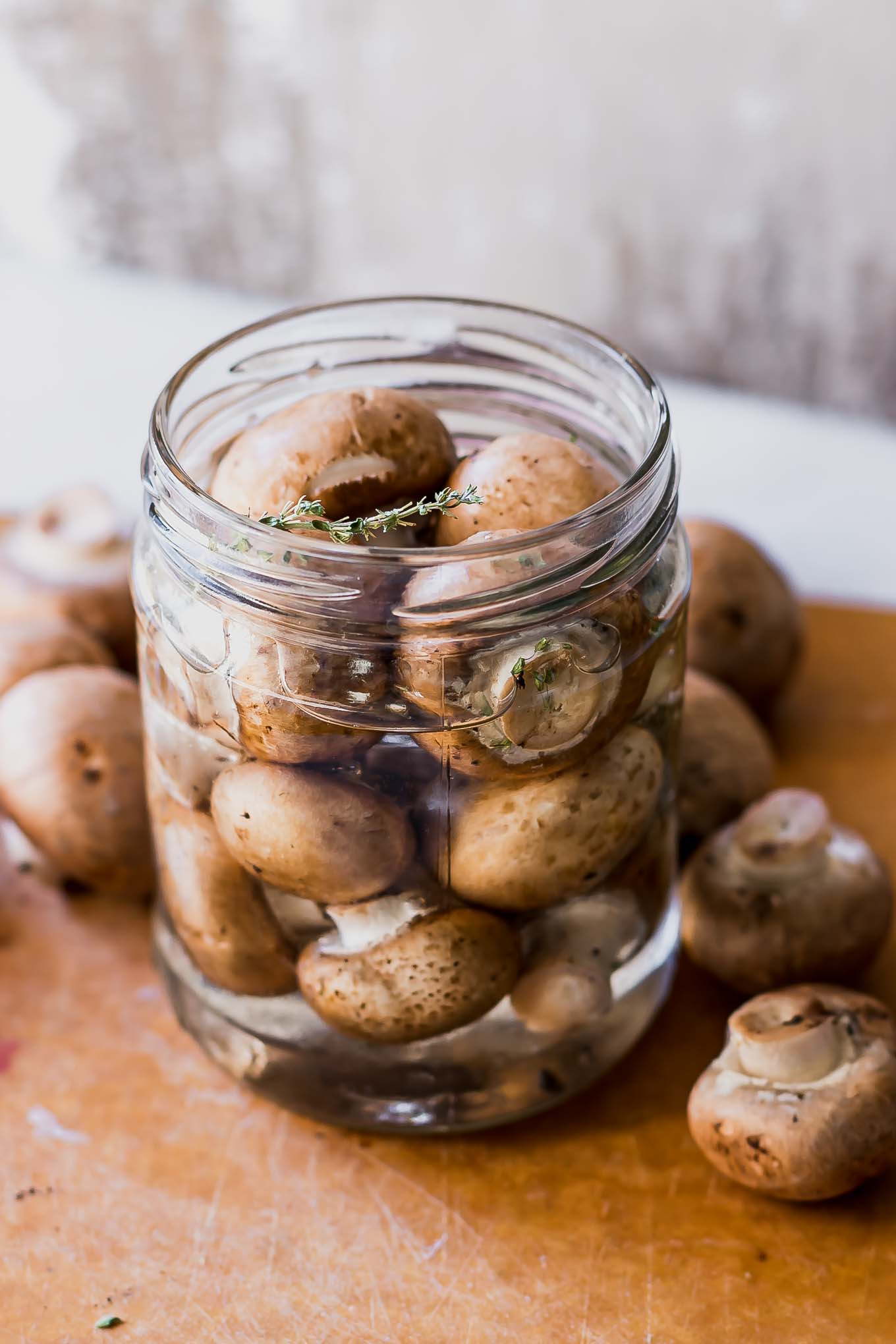 pickled mushrooms in a jar on a wood table