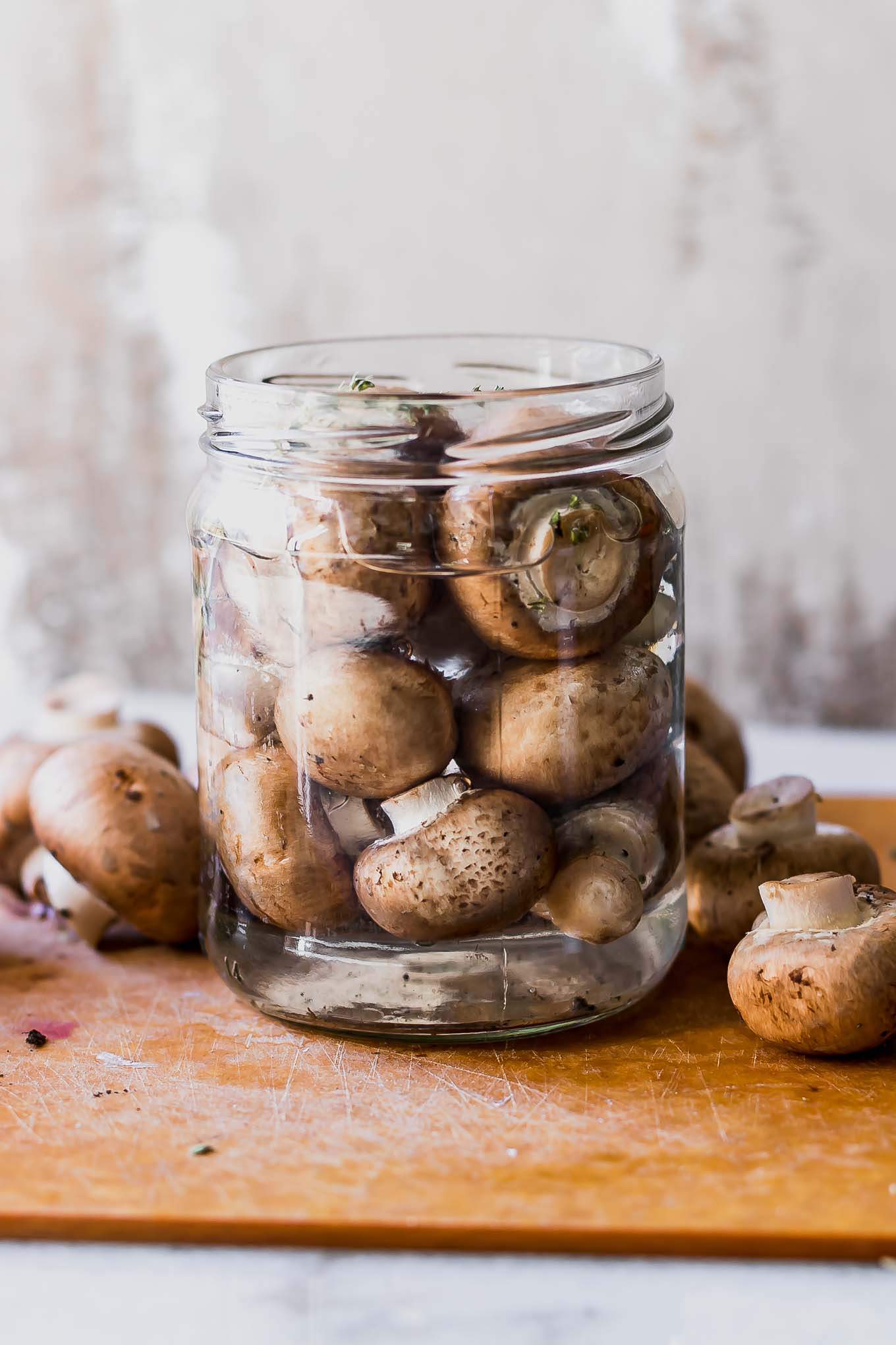 a jar of pickled mushrooms on a wood table