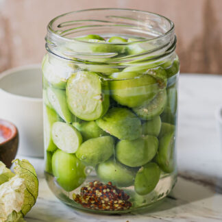 refrigerator pickled tomatillos in a jar on a white table