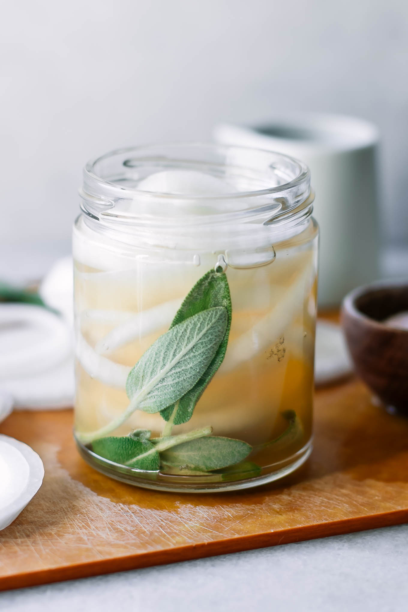 refrigerator pickled onions in a glass jar on a white table