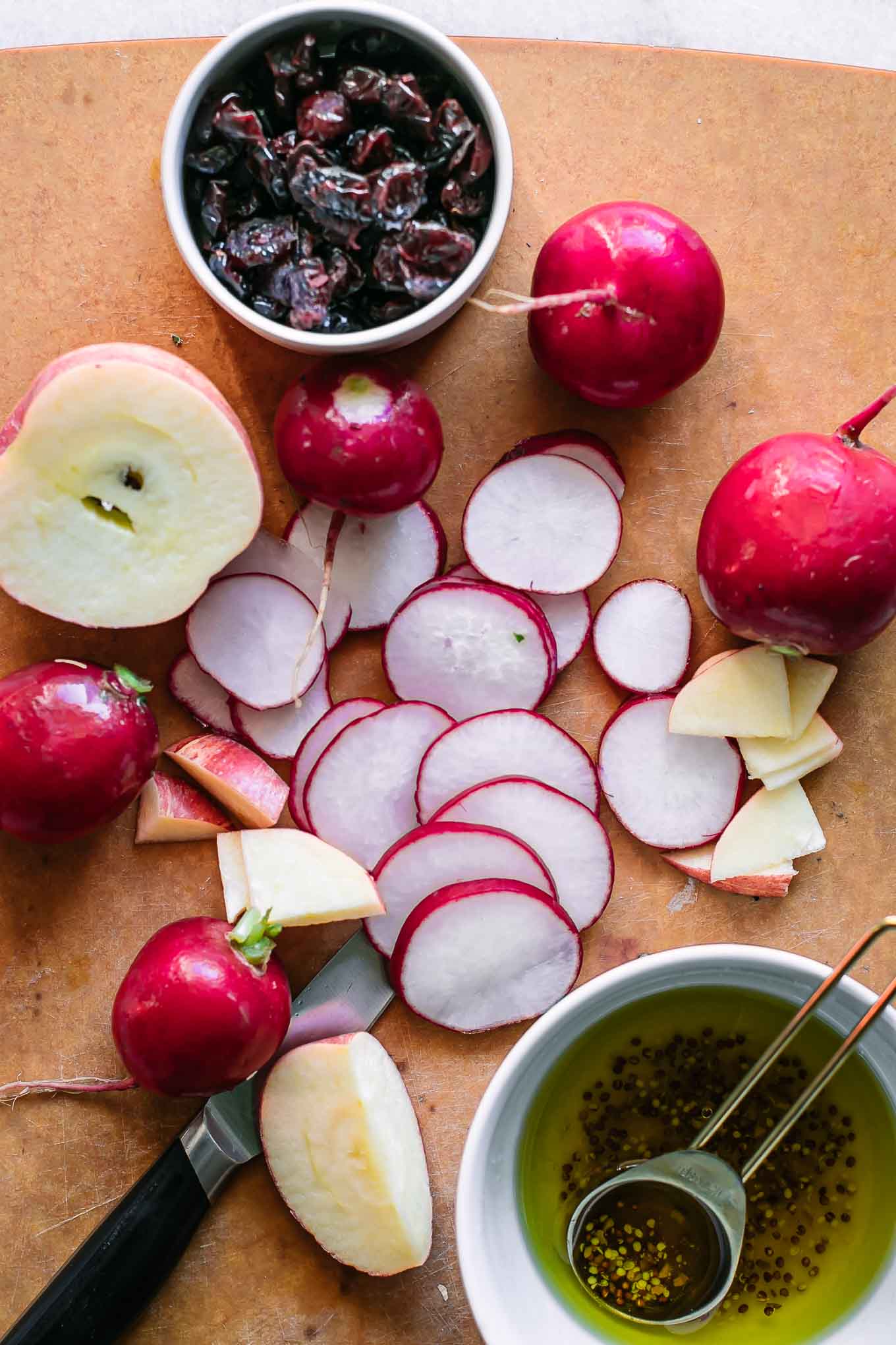 sliced radishes and apples on a cutting board