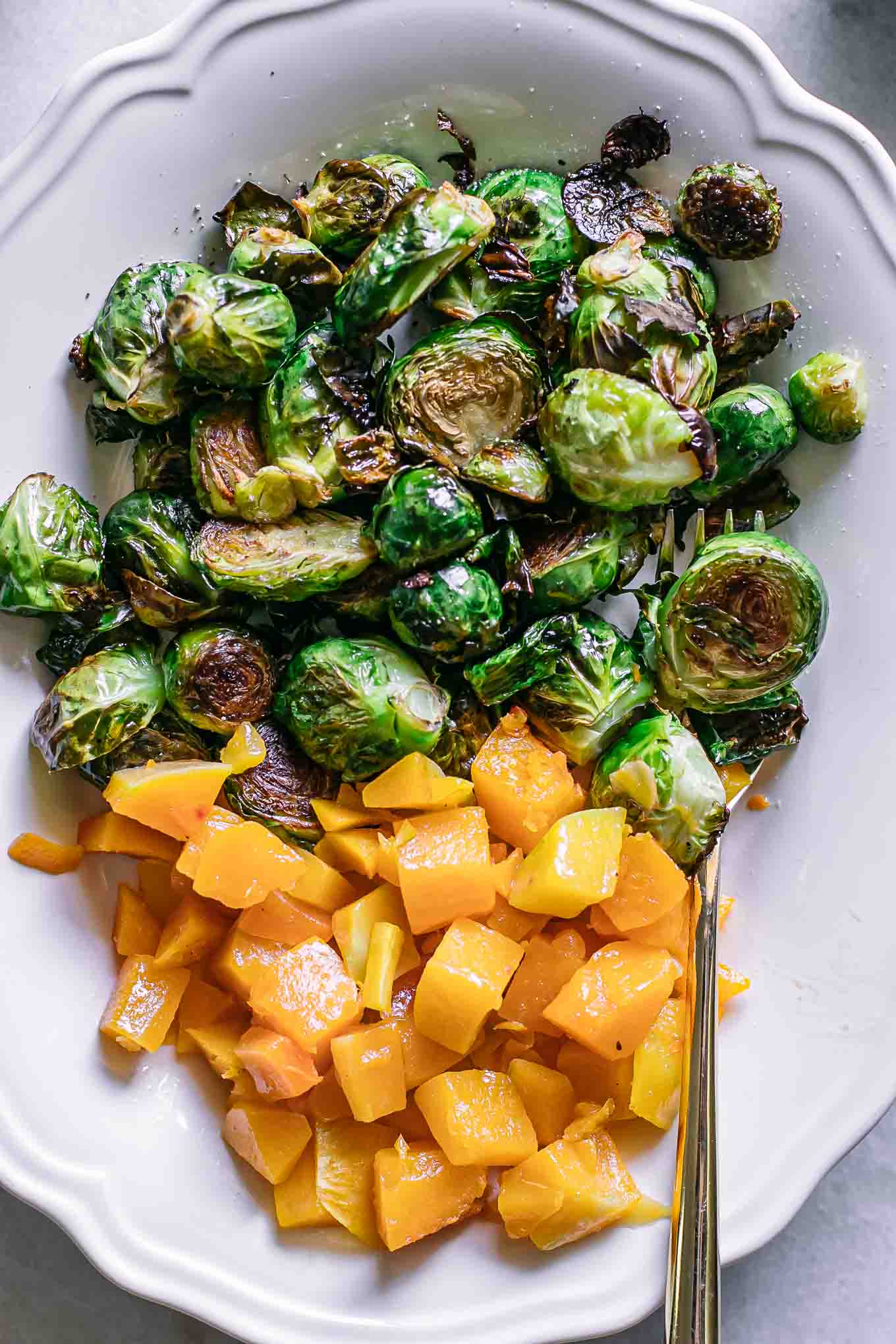 roasted butternut squash and brussels sprouts on a white plate