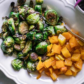 baked butternut squash and brussels sprouts on a white side dish