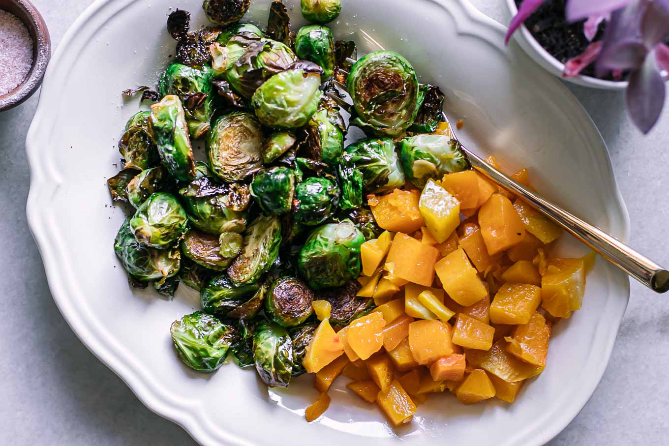 baked butternut squash and brussels sprouts on a white side dish