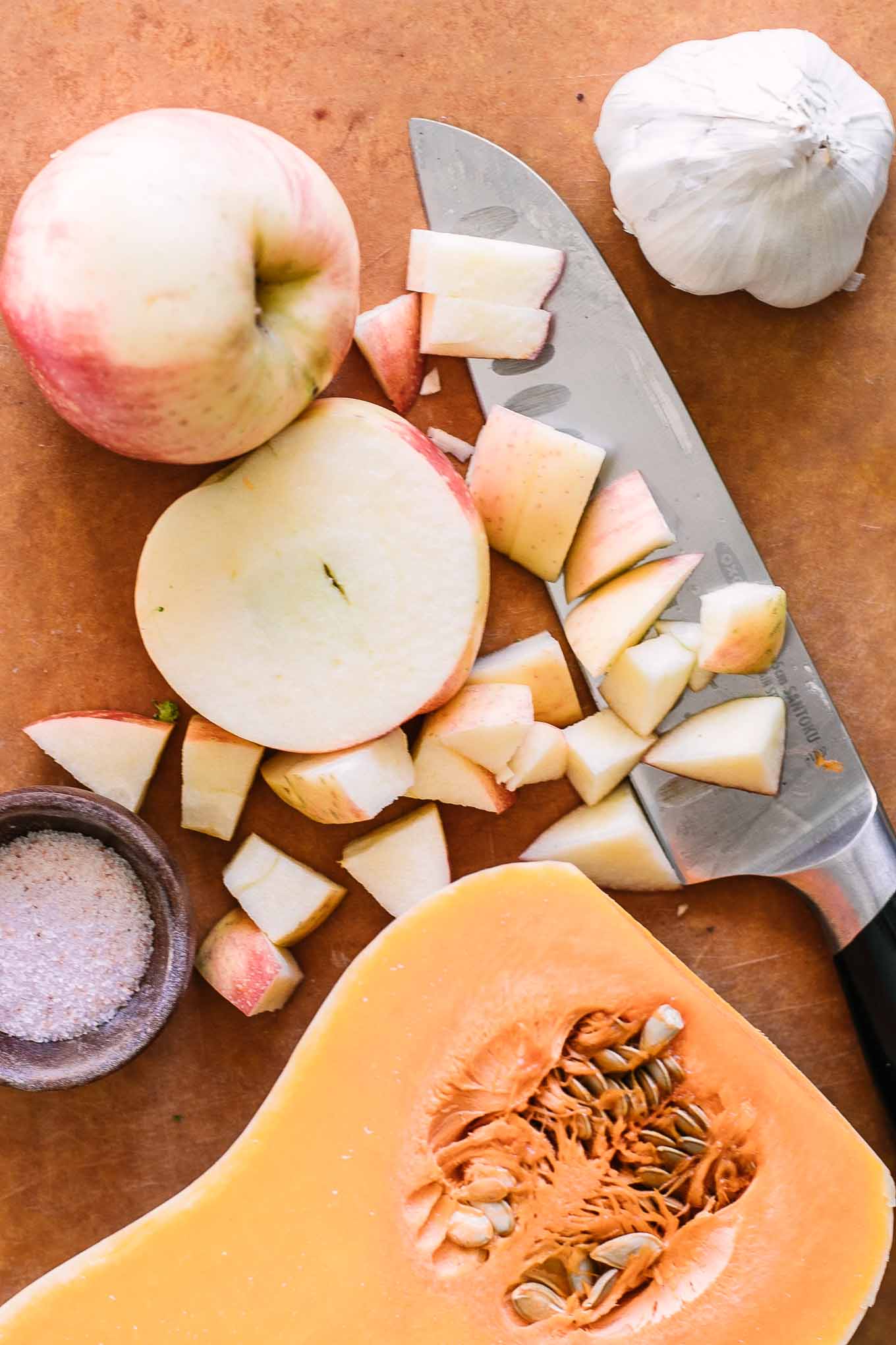 sliced butternut squash and apples on a wood cutting board