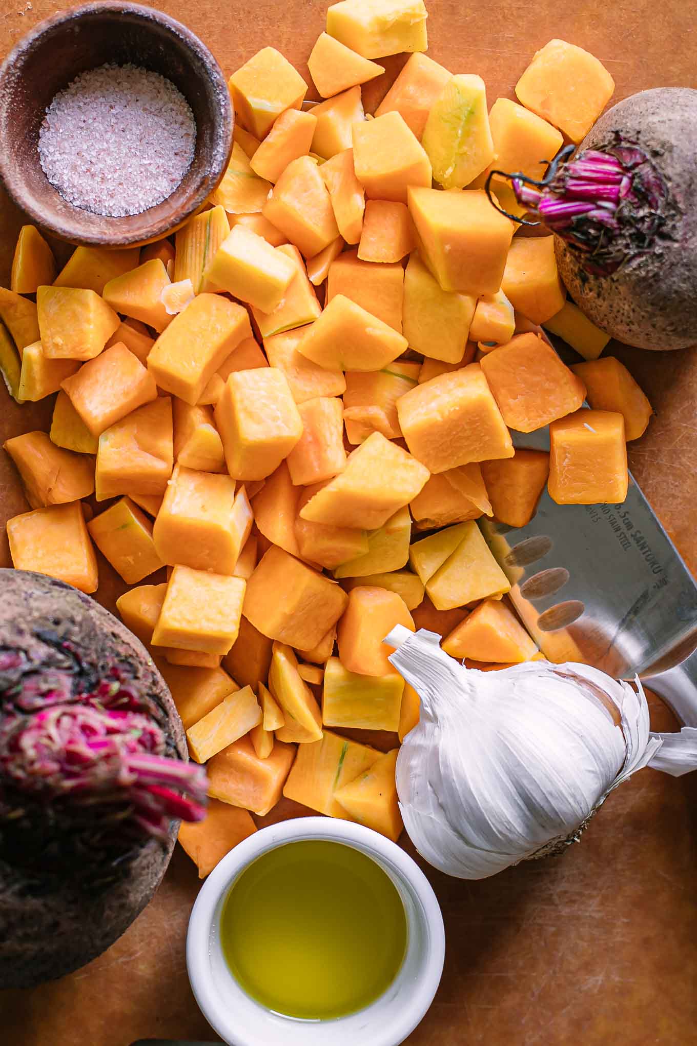 cut butternut squash and whole beets on a cutting board