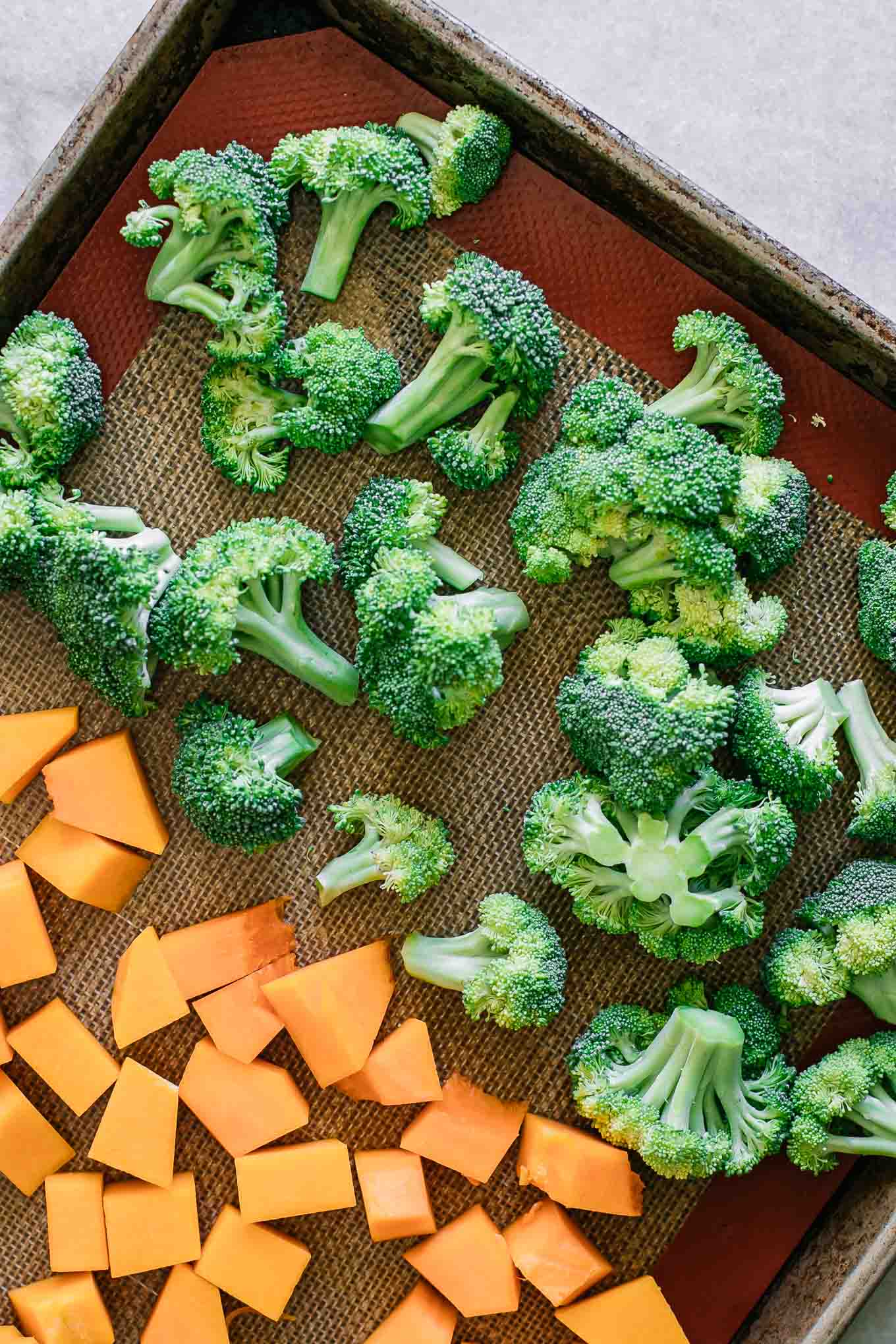broccoli florets and cut butternut squash on a baking sheet before roasting