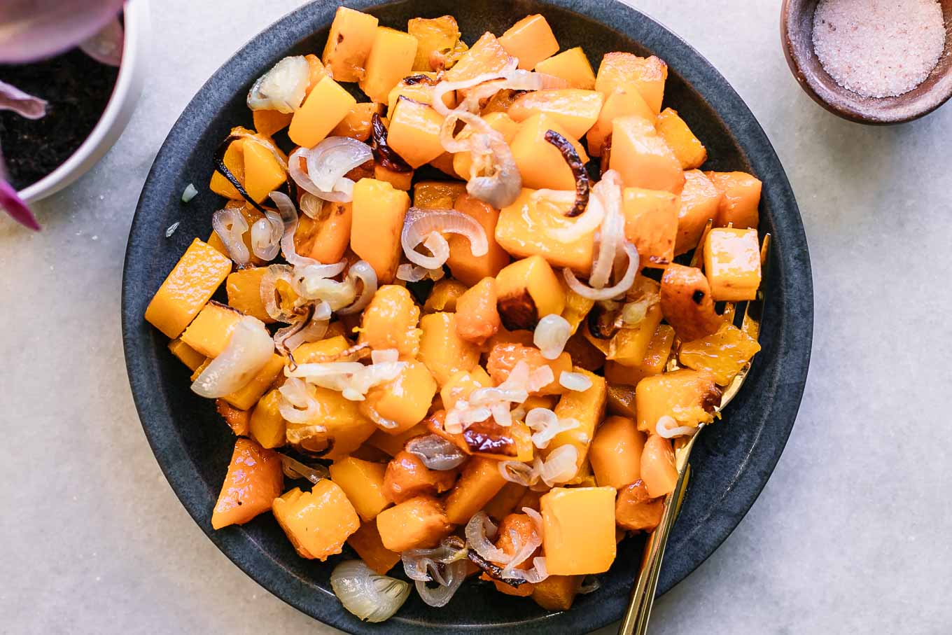 a blue side dish with baked butternut squash and shallots