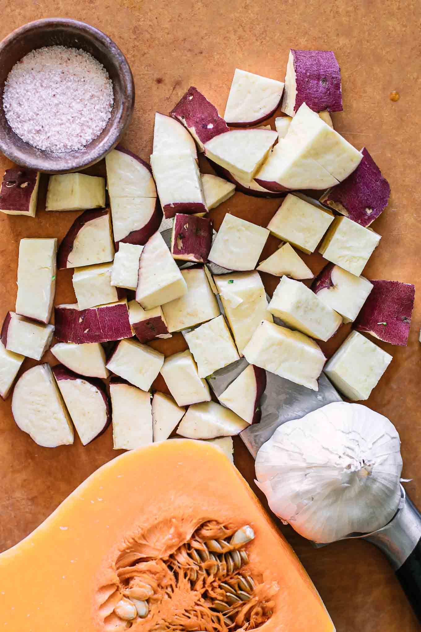 cut butternut squash and sweet potatoes on a cutting board