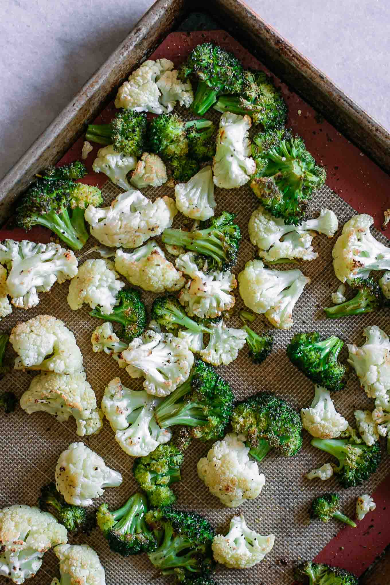 baked broccoli and cauliflower on a sheet pan after roasting