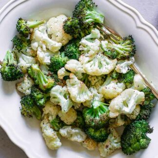 a roasted cauliflower and broccoli florets side dish on a white table