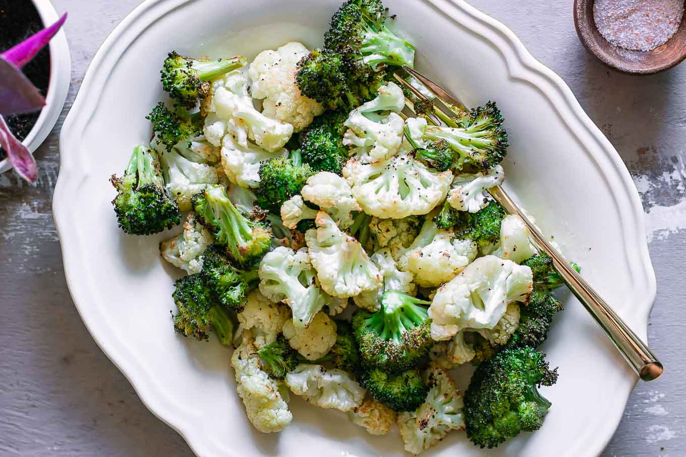 a roasted cauliflower and broccoli florets side dish on a white table