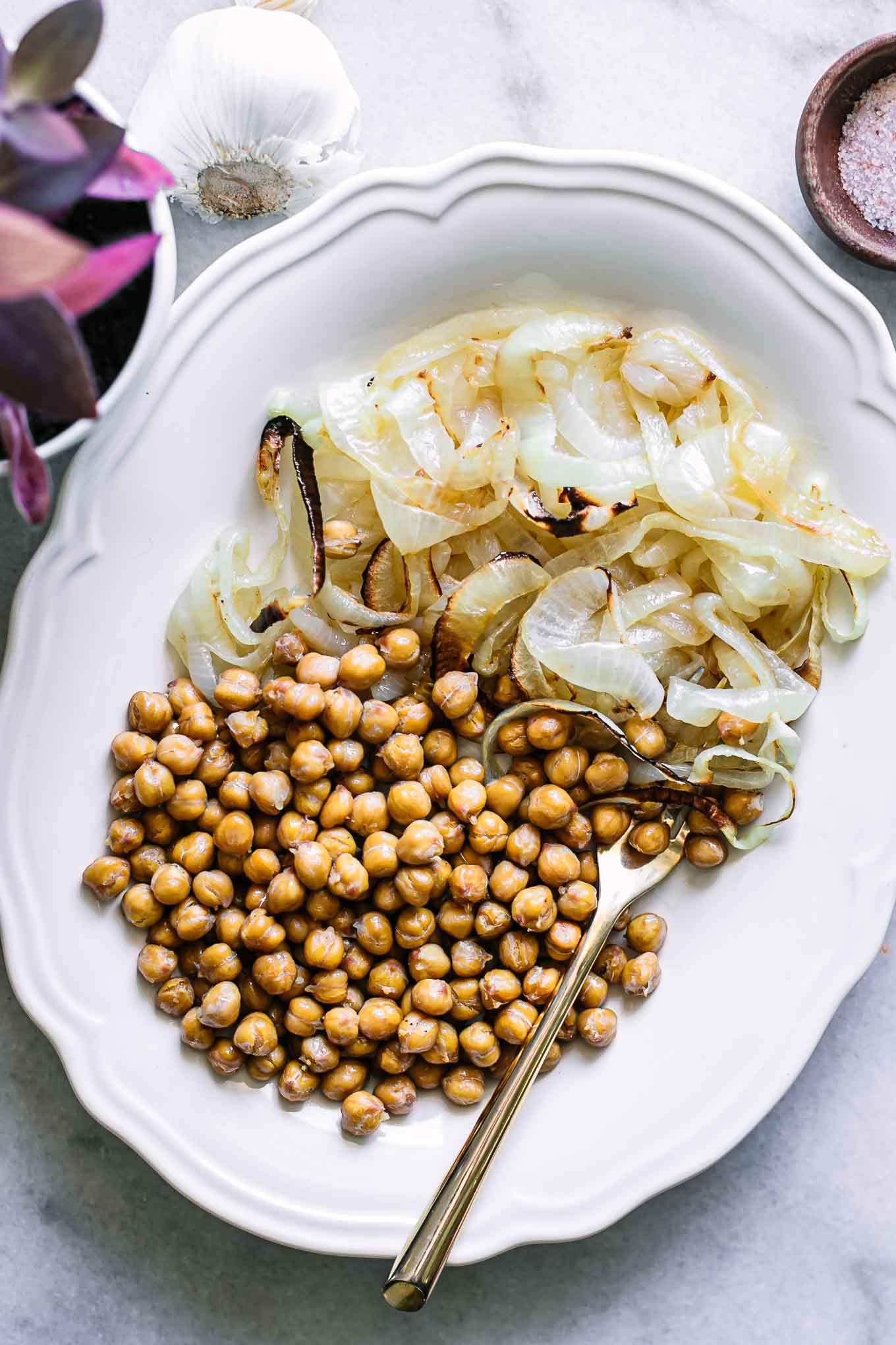roasted chickpeas and onions on a white plate with a gold fork