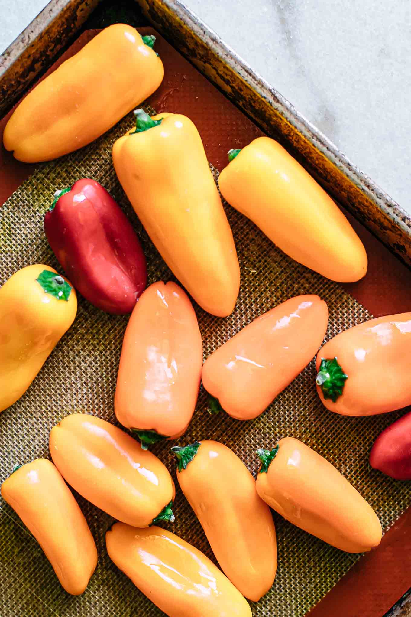 raw mini bell peppers on a baking sheet before roasting