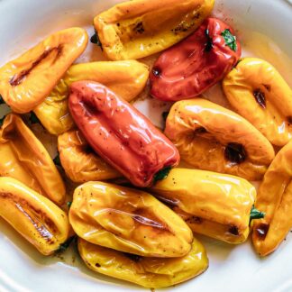 roasted small peppers on a white plate