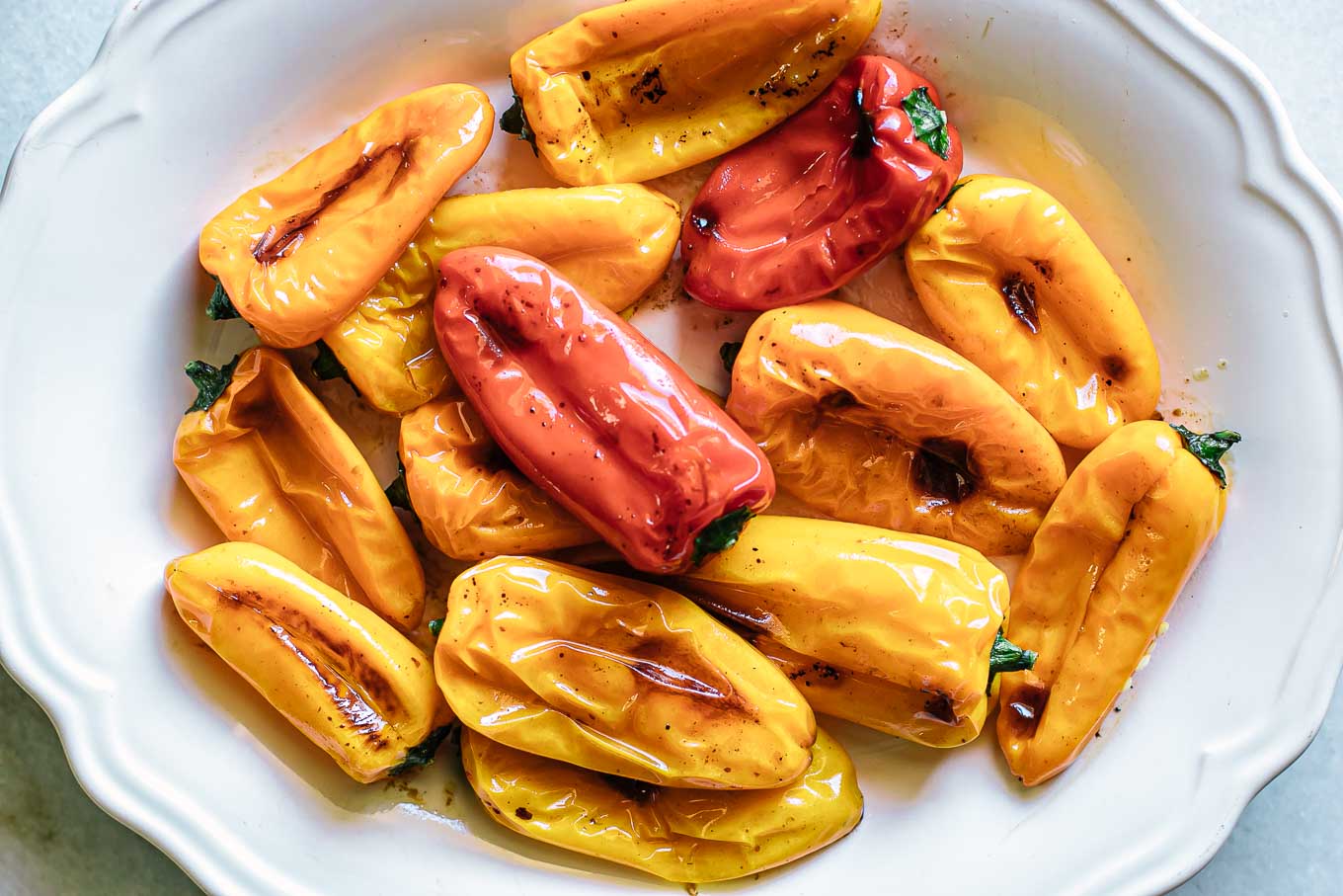 roasted small peppers on a white plate