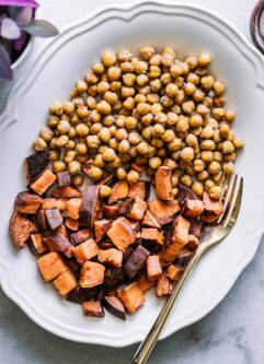 roasted chickpeas and sweet potatoes on a white plate with a gold fork