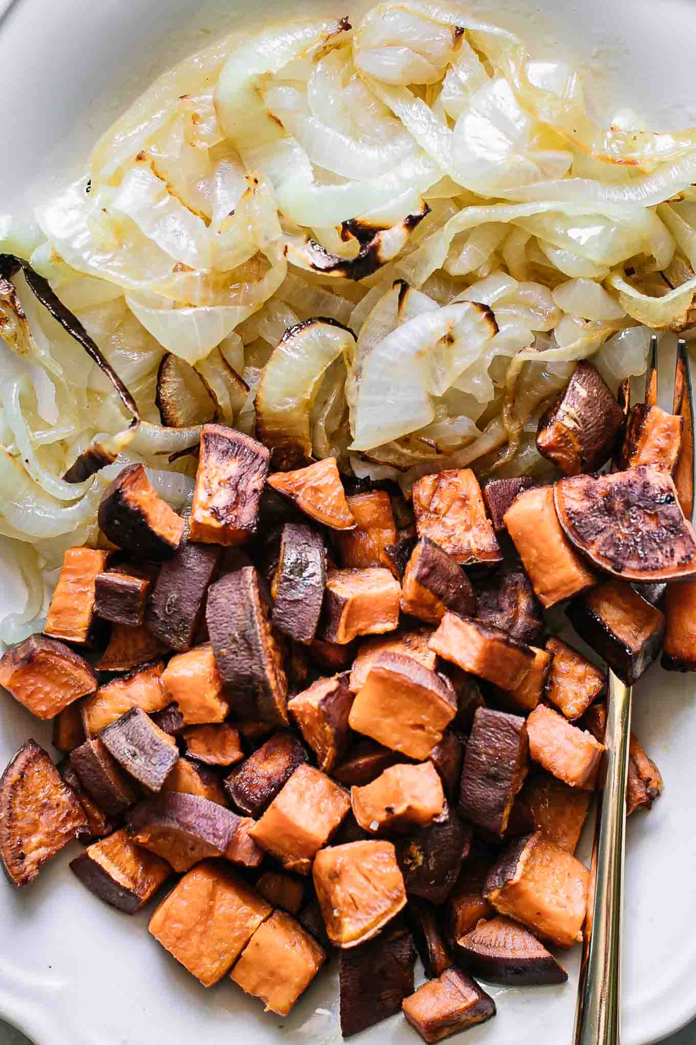 baked onions and sweet potatoes on a white plate