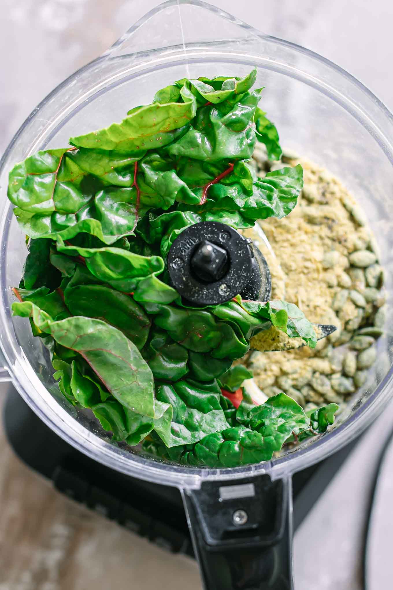 fresh chard leaves and pesto ingredients in a food processor before blending