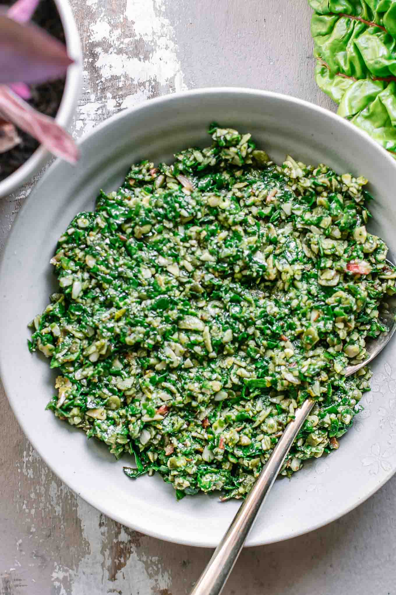 chard leaves pesto sauce in a bowl with a gold fork