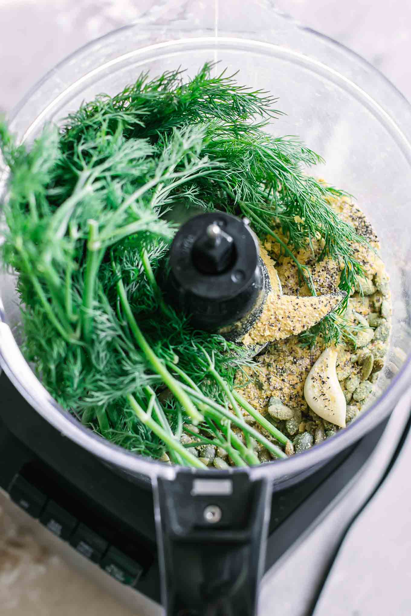 fresh dill and pesto ingredients in a food processor