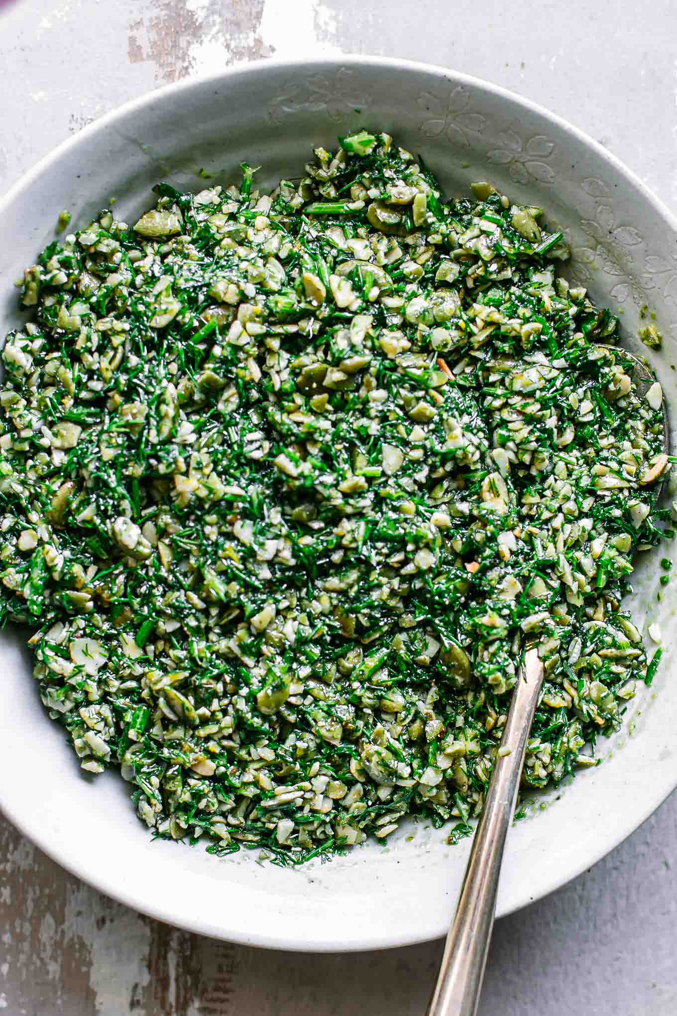 a close up photo of dill pesto sauce in a bowl