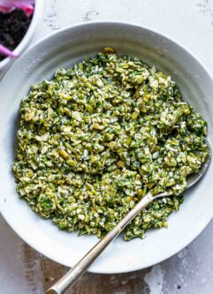 mint pesto sauce in a white bowl with a gold fork