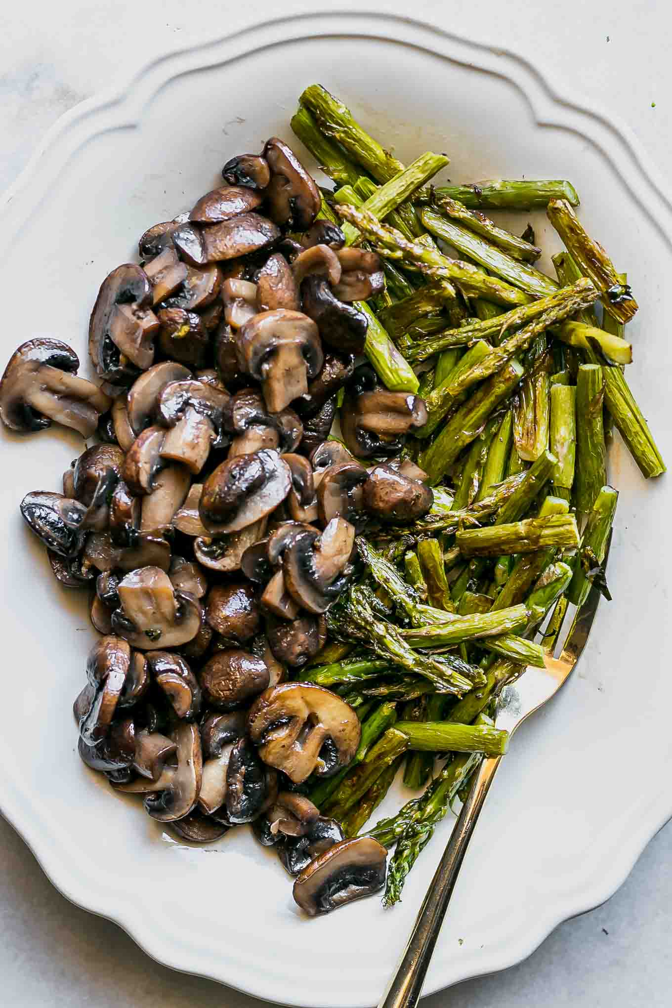 cut mushrooms and asparagus on a white plate