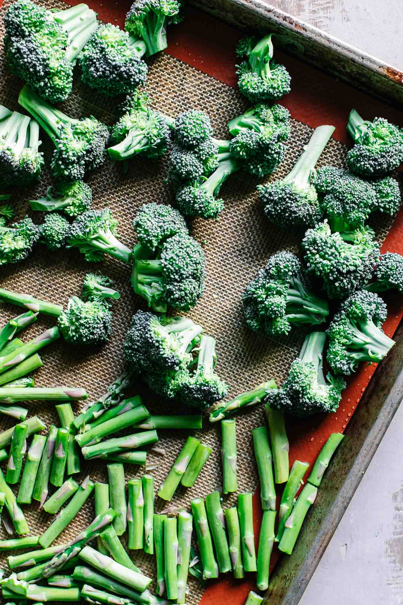 cut asparagus and broccoli on a baking sheet before roasting