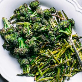 roasted broccoli and asparagus on a white side dish plate