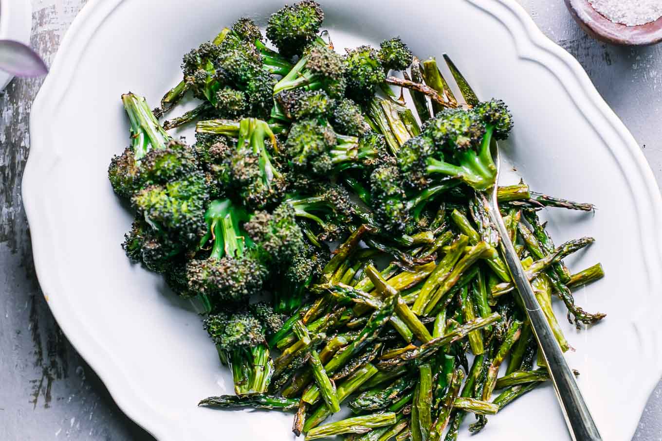 roasted broccoli and asparagus on a white side dish plate