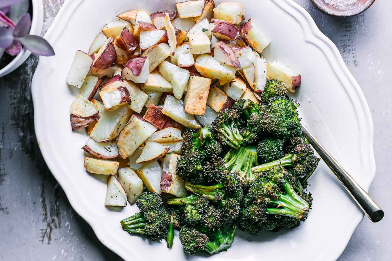 a white side dish with roasted potatoes and broccoli