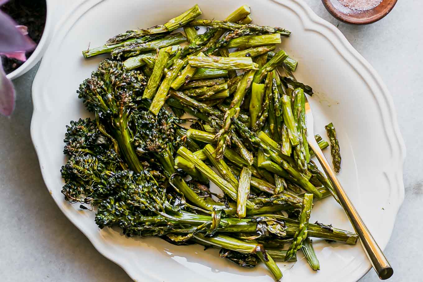 baked broccolini and asparagus on a white side dish