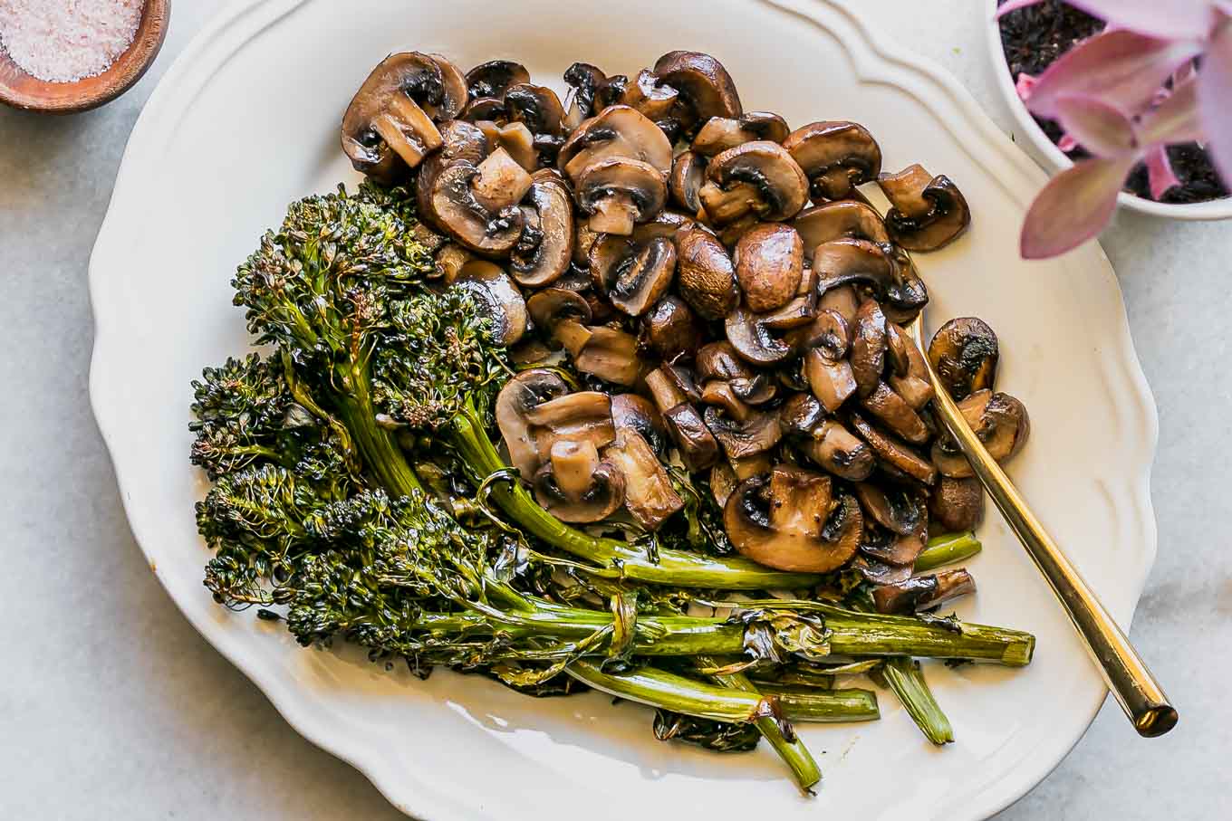 roasted mushrooms and broccolini on a white side dish plate